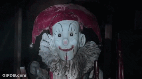 Jester Statue With Bloody Mouth Sitting In Chair GIF