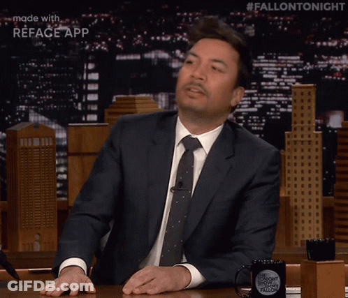 Jimmy Fallon Is Sitting At A Table With A Fallon Tonight Mug GIF