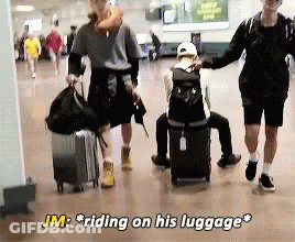 JM Riding On Luggage While Man Sits On Suitcase GIF