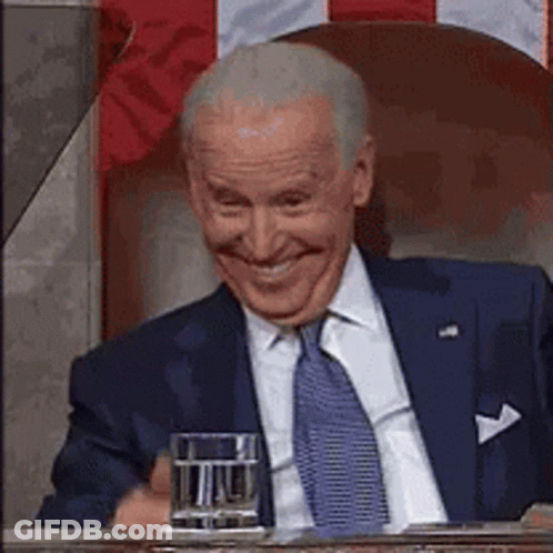 Joe Biden Smiling At Table With Glass Of Water GIF