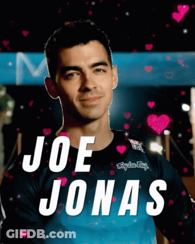 Joe Jonas Is Surrounded By Pink Hearts And A Blue Shirt GIF