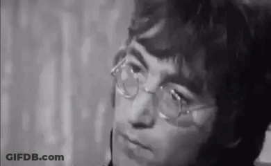 John Lennon Making Funny Face In Suit And Tie GIF