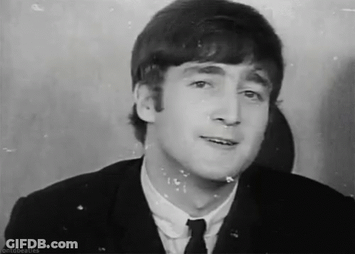 John Lennon Making Funny Face In Suit And Tie GIF