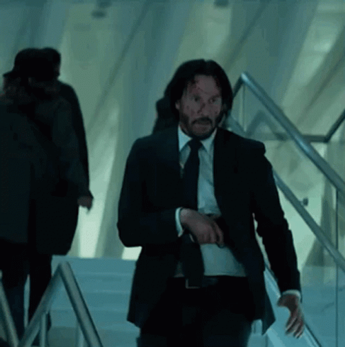 John Wick Hiding His Gun GIF
