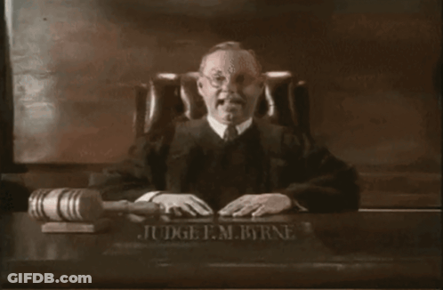 Judge F.M. Byrne Sitting At Desk With Gavel GIF
