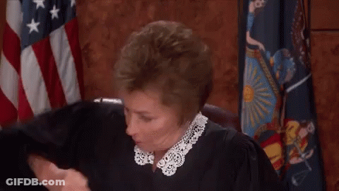 Judge Fist Bumping In Front Of American Flag GIF