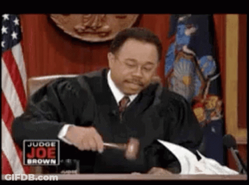 Judge Holding Gavel In Front Of American Flag GIF