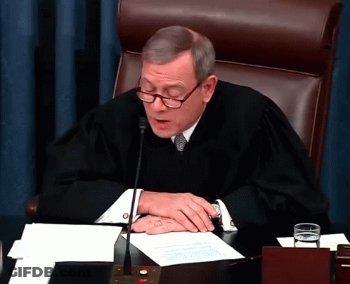 Judge In Robe Sitting At Desk GIF