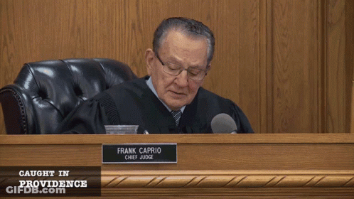 Judge In Robe Sitting At Desk GIF