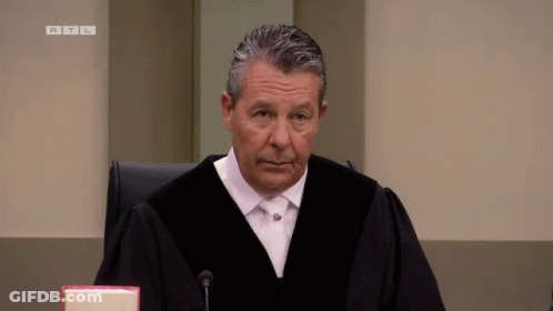 Judge In Robe Sitting At Microphone RTL GIF