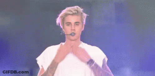 Justin Bieber Is Holding A Microphone In His Mouth And Says `` Love All My Beliebers '' . GIF