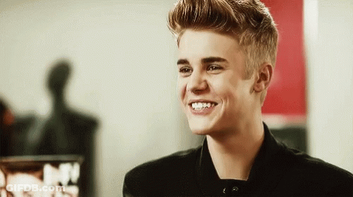 Justin Bieber Is Smiling And Looking At The Camera In A Black Jacket . GIF