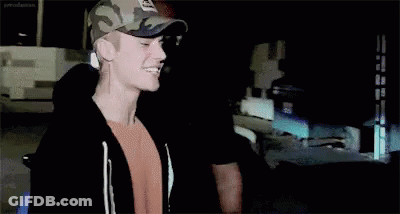 Justin Bieber Is Wearing A Camouflage Hat And Smiling . GIF