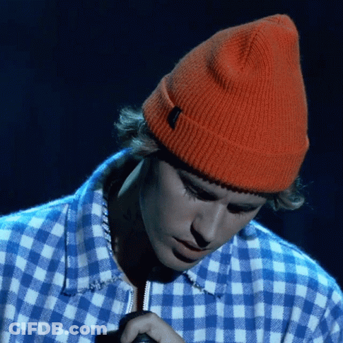 Justin Bieber Wearing An Orange Beanie And A Blue And White Plaid Shirt GIF