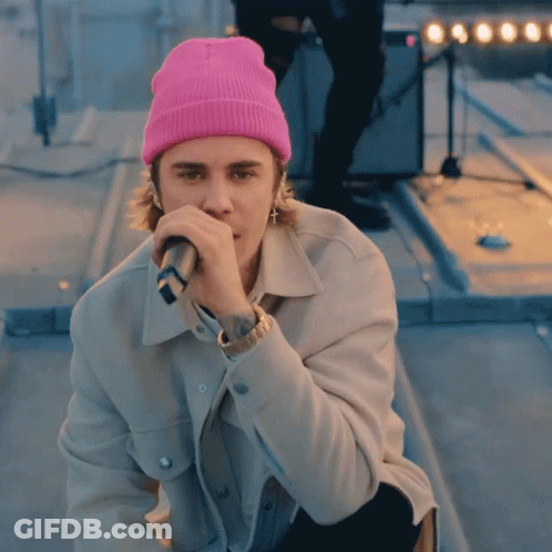 Justin Bieber Wearing Pink Beanie And Holding Microphone GIF
