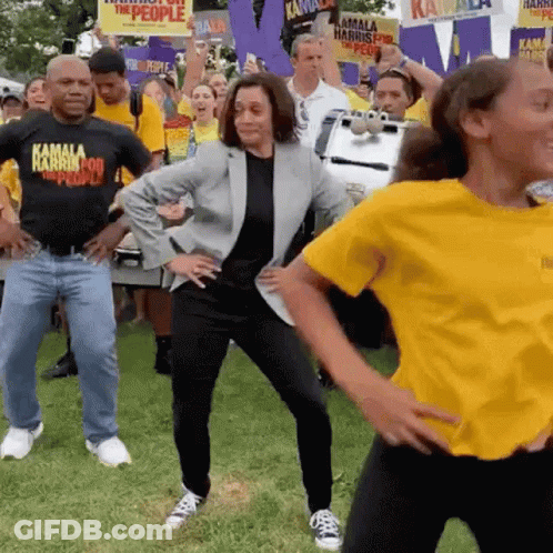 Kamala Harris Is Dancing With A Group Of People Wearing Yellow Shirts That Say Kamala Harris For The People . GIF