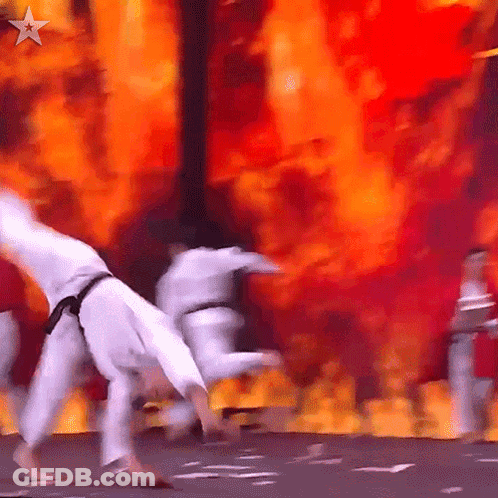 Karate Fighters Performing On Stage With Fire GIF