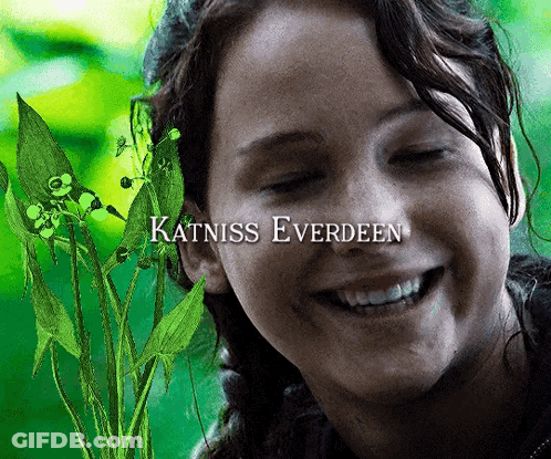 Katniss Everdeen Is Smiling With A Plant Behind Her GIF