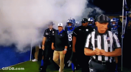 Kentucky Football Players Are Walking On The Field With Smoke Coming Out Of The Tunnel GIF