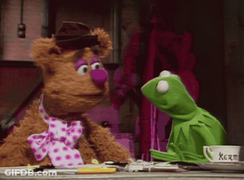 Kermit The Frog And Fozzie Bear Are Sitting Next To Each Other On A Table GIF