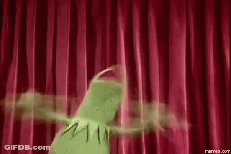 Kermit The Frog Is Dancing On A Stage With A Red Curtain Behind Him . GIF
