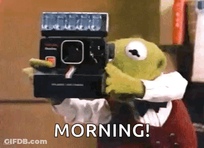 Kermit The Frog Is Holding A Polaroid Camera In His Hands And Saying Morning . GIF