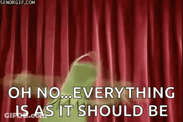 Kermit The Frog Is Standing In Front Of A Red Curtain . GIF