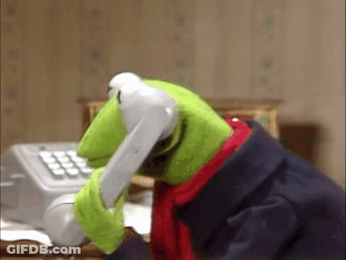 Kermit The Frog Is Talking On A Telephone While Sitting At A Desk . GIF