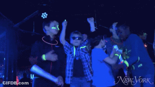 Kids Dancing With Glow Sticks In Front Of New York Ad GIF