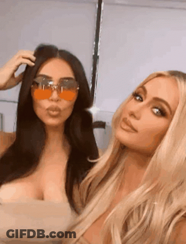 Kim Kardashian And Paris Hilton Are Posing For A Picture Together While Wearing Sunglasses . GIF
