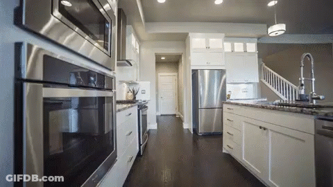 Kitchen With White Cabinets And Stainless Steel Appliances GIF