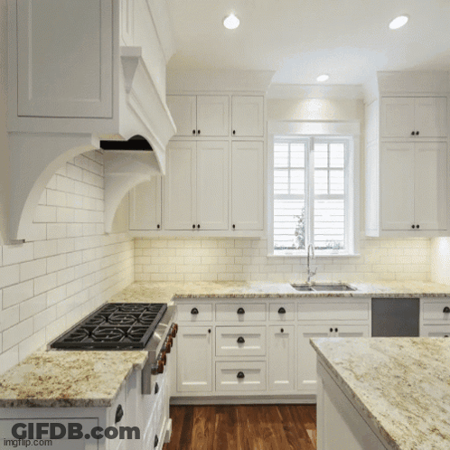 Kitchen With White Cabinets Granite Countertops And Large Window GIF
