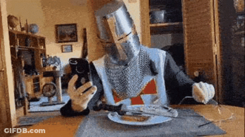 Knight At Table With Plate Of Food And Fork GIF