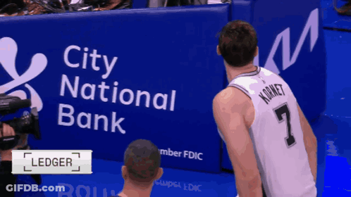 Kornet Is Standing In Front Of A City National Bank Banner GIF