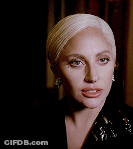 Lady Gaga In Black Jacket Holding Trophy In Mouth GIF