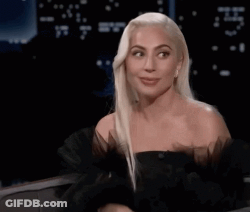 Lady Gaga Sitting In Chair With Hands In Air GIF