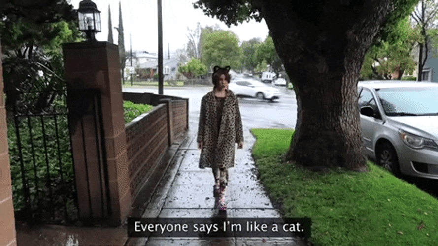 Lady Wearing Cat Themed Headband And Cardigan GIF