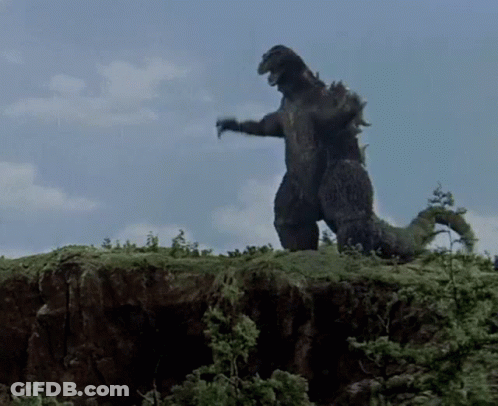 Large Black Dinosaur Standing On Hill GIF