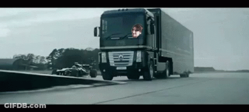 Large Black Truck Driving Next To Race Car GIF