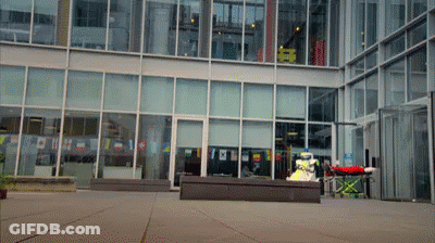 Large Building With Red Ambulance Parked Out Front GIF