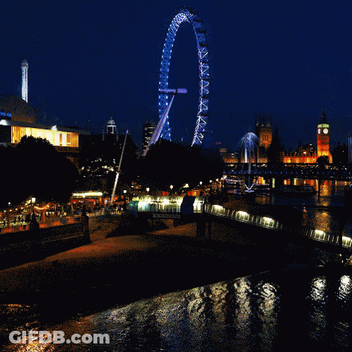 Large Ferris Wheel Lit Up At Night In City GIF