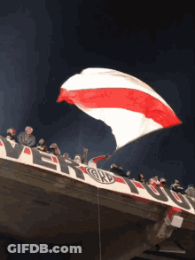 Large Red And White Flag Flying Over River Banner GIF