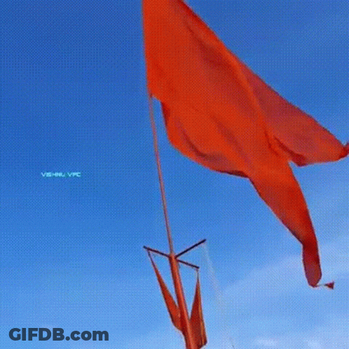Large Red Flag Flying In Wind Against Blue Sky GIF