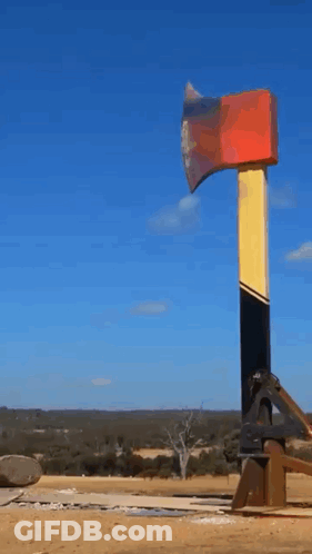 Large Red Yellow And Black Axe In Field GIF