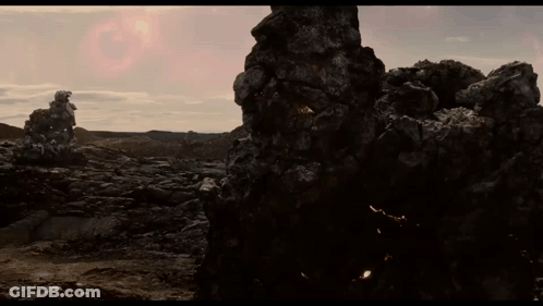 Large Rock In Desert With Pink Sun GIF