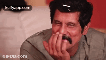 Laughing Man With Mustache Covering Mouth GIF