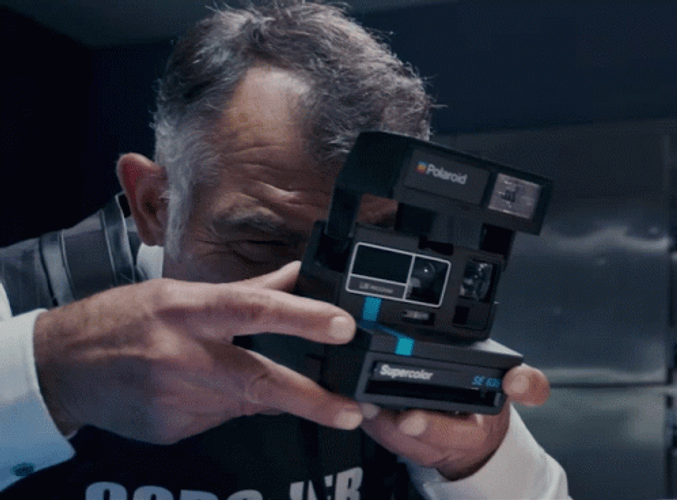 Le Coroner Using Polaroid Camera GIF
