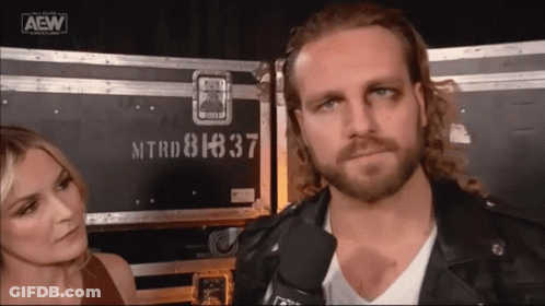 Leather Jacket Man Next To Woman At AEW Logo GIF
