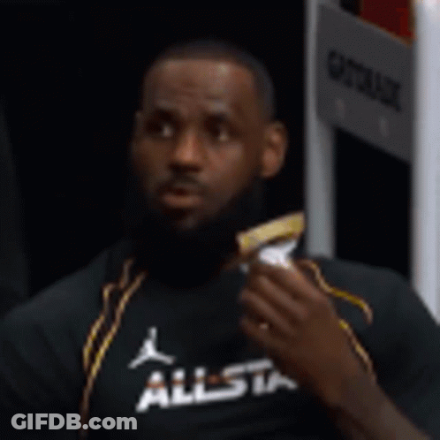 Lebron James Is Sitting In A Locker Room Eating A Snack . GIF