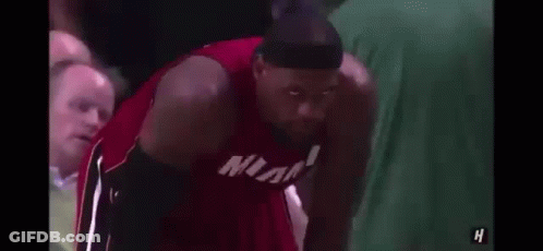 Lebron James Is Wearing A Headband And A Miami Jersey While Sitting On The Bench . GIF